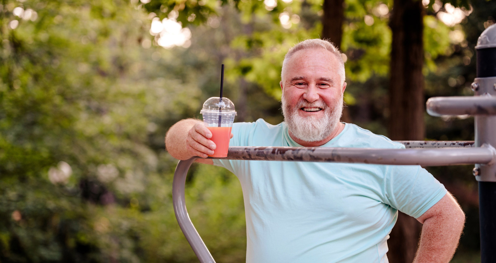 Older male in park with a smoothie