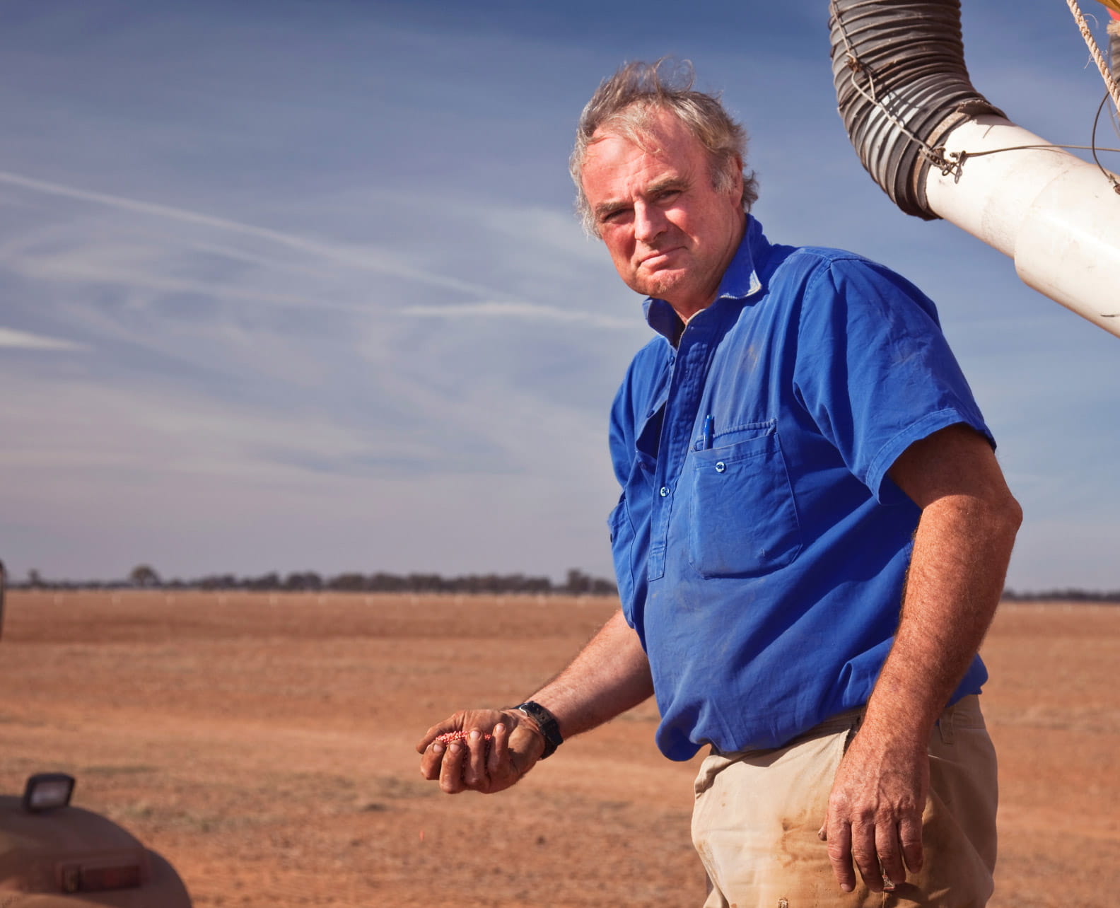 Older male farmer holding seeds