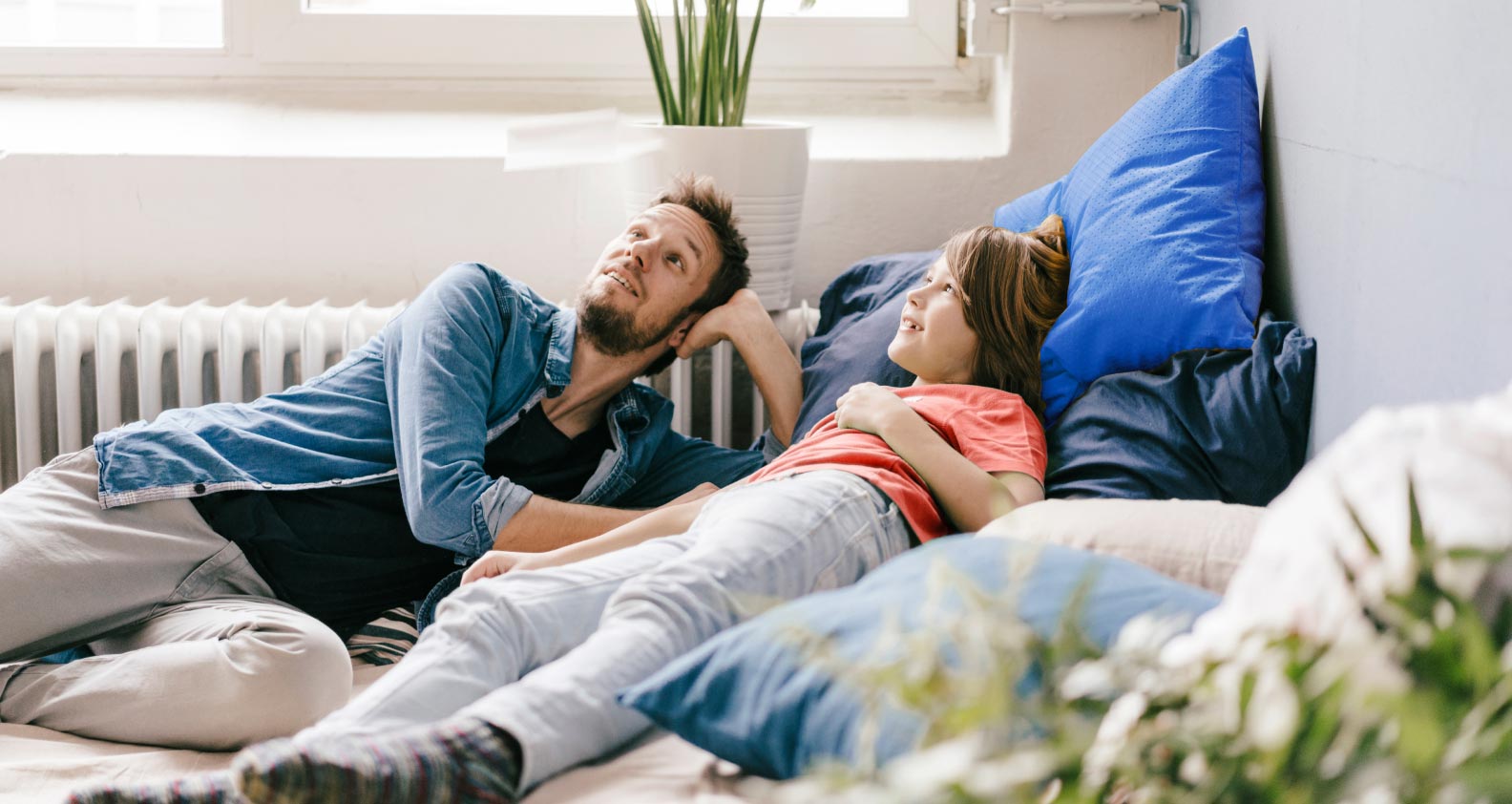 Dad and son lying on beanbag in living room