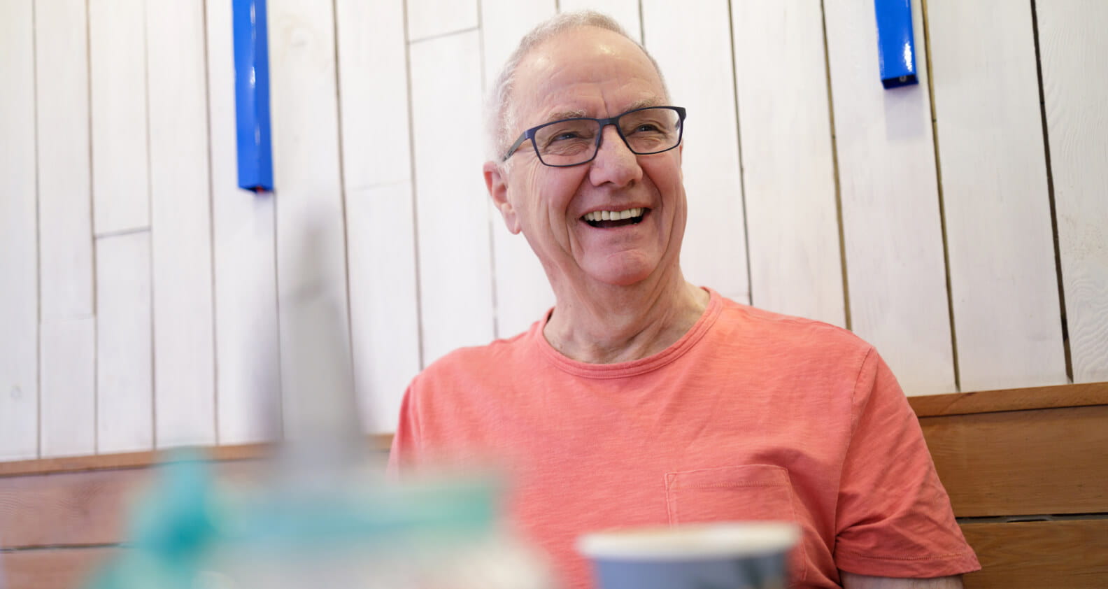 Old man laughing at a cafe