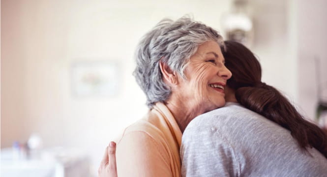 elderly female hugging daughter