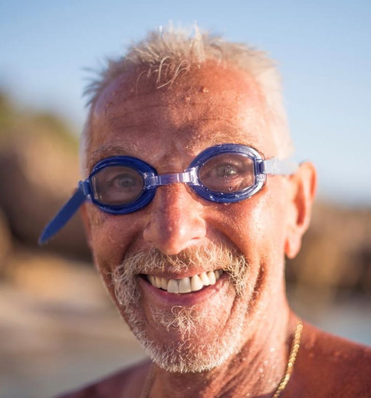 Elderly male with goggles at the beach