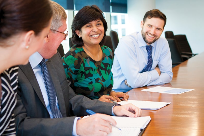 Sunsuper staff smiling together at meeting room table